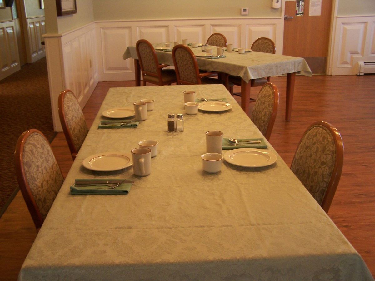 A neatly arranged dining table with plates and napkins in a cozy dining room.