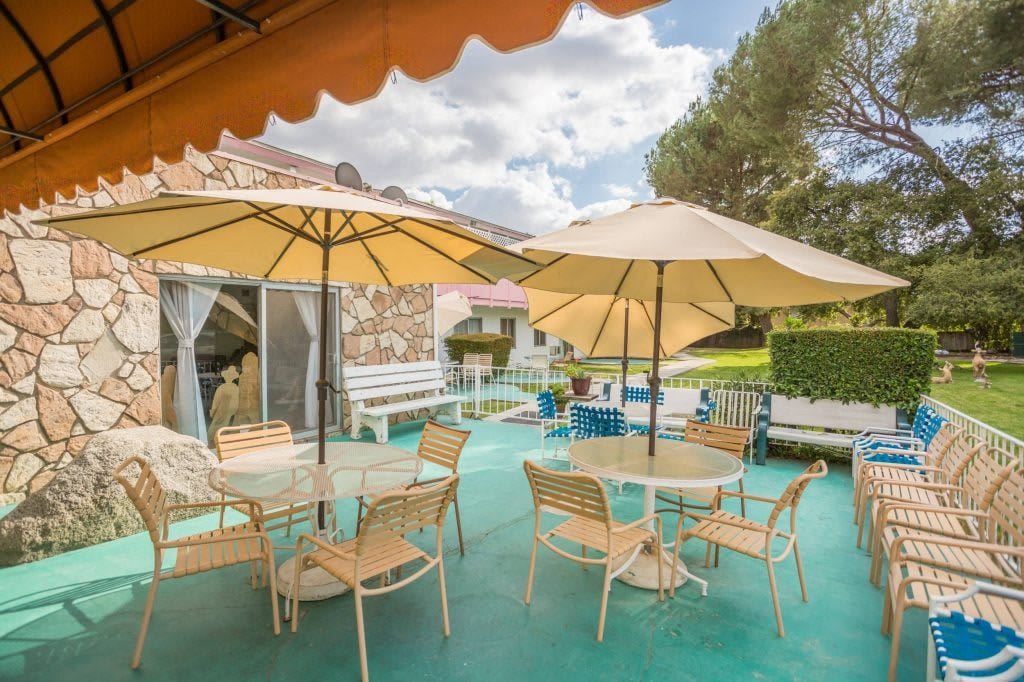 A relaxing outdoor patio area with tables, chairs, and large umbrellas on a sunny day.