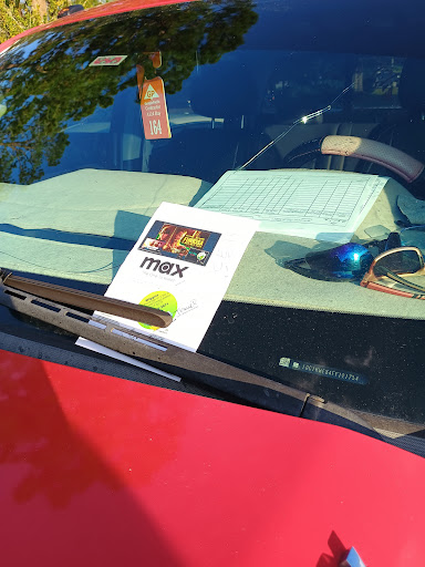 A note placed on the dashboard of a parked car.