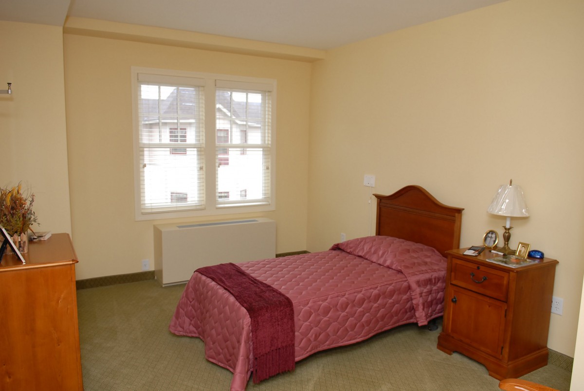A simple bedroom with a single bed and a window.
