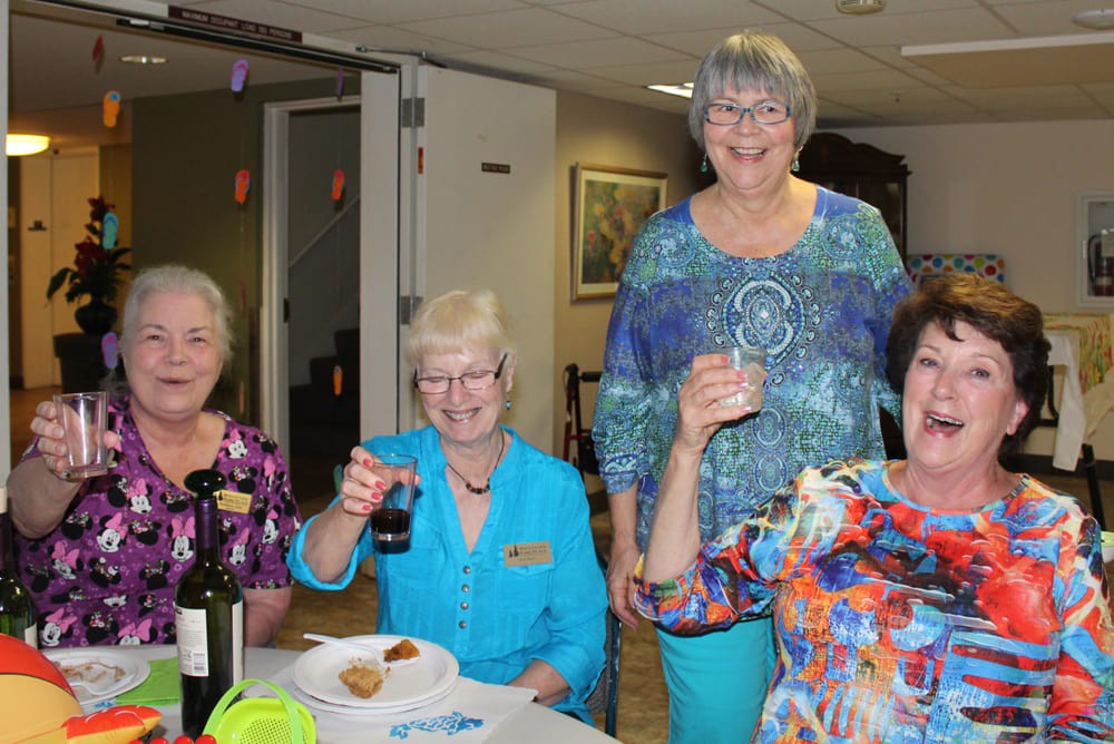 A group of women enjoying a gathering indoors with food and drinks.
