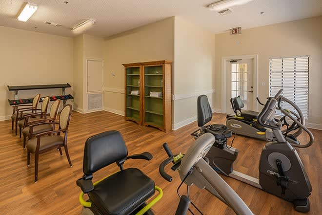 A cozy fitness room with stationary bikes and a wooden floor.