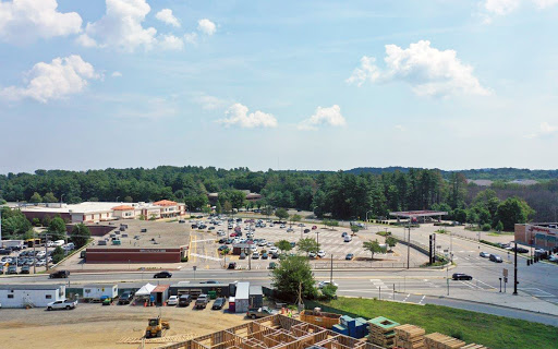 A view of a commercial area featuring a parking lot and ongoing construction.