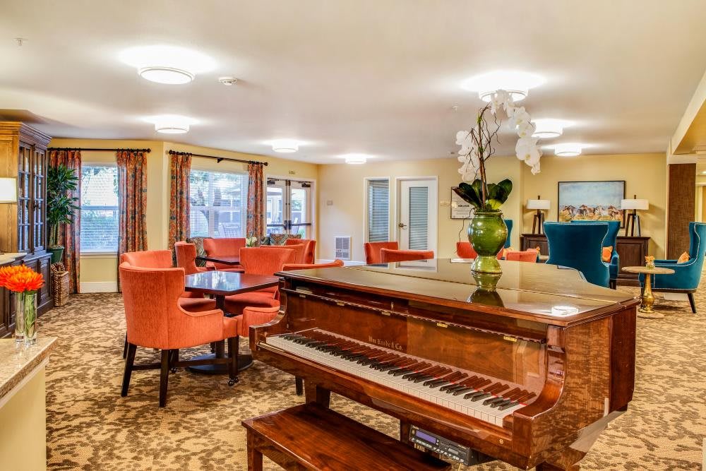 A cozy living room with a piano and comfortable seating.