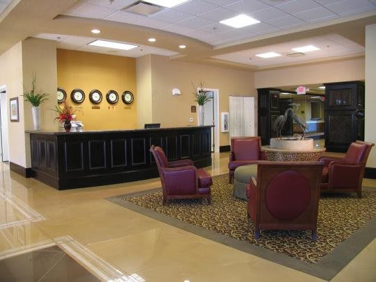 A spacious hotel lobby with a reception desk and comfortable seating areas.