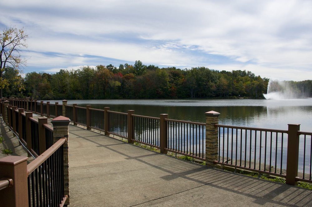 A scenic view of a lakeside pathway with trees in the background.