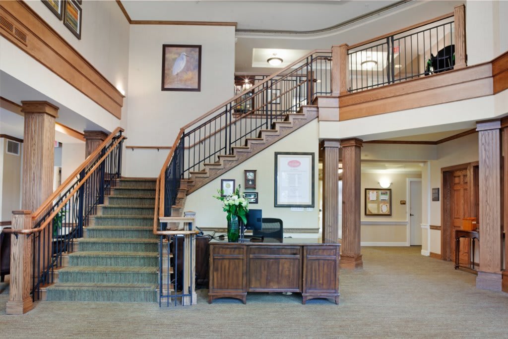 A spacious and elegant lobby featuring a grand staircase and reception desk.