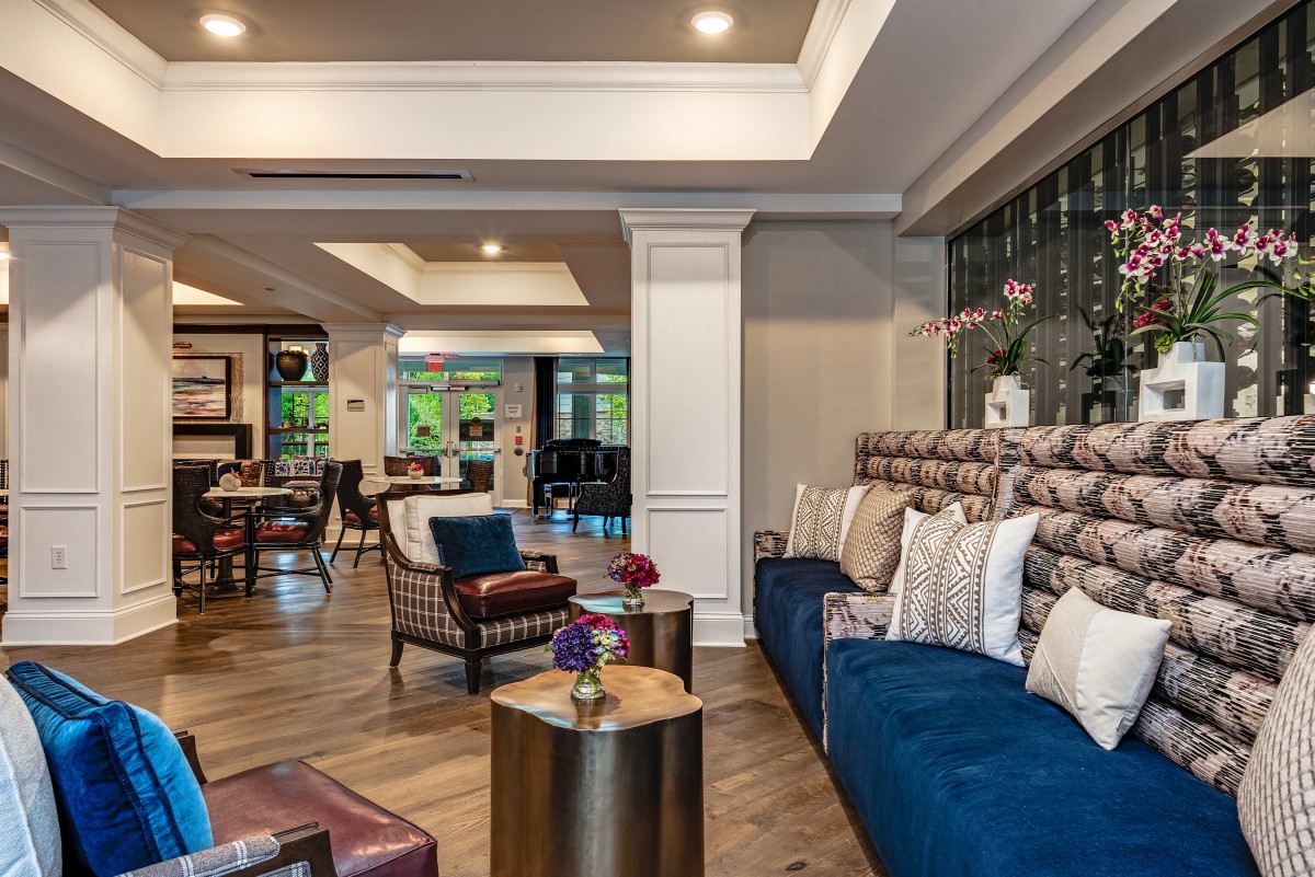 A stylish and spacious living room featuring modern decor with a comfortable seating area, wooden flooring, and elegant furnishings.