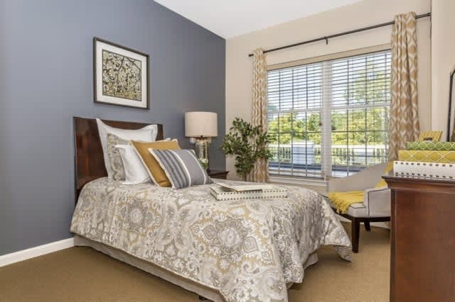 A cozy, well-decorated bedroom with patterned bedding and stylish decor elements.