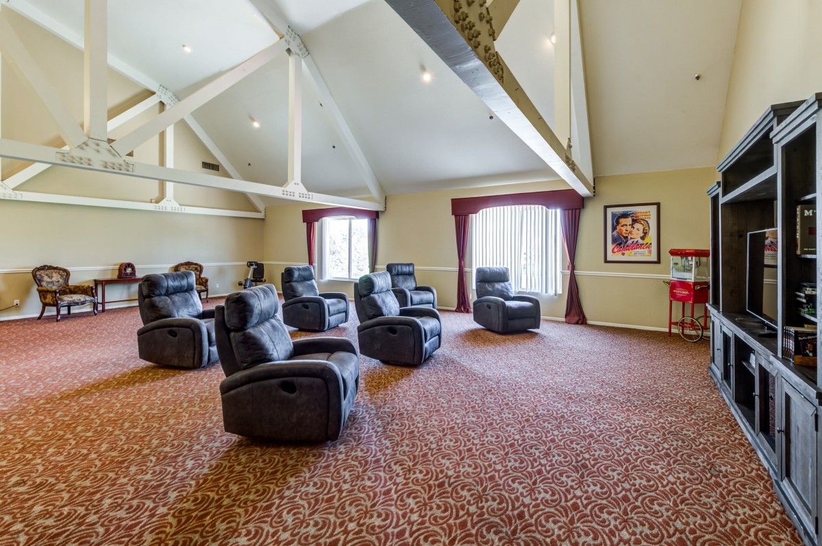 A spacious home theater room with recliner chairs and vaulted ceilings.