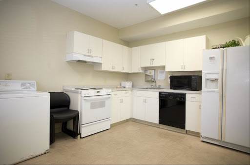 A spacious kitchen featuring white cabinets and essential appliances.