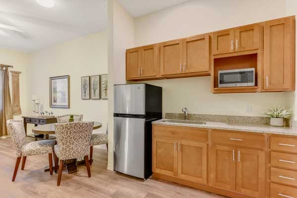 A modern kitchen with wooden cabinets and a dining area.
