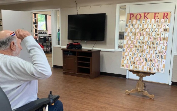An indoor room with a television, cabinet, and a game board on an easel.