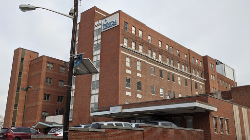 A view of a red brick hospital building with signage.