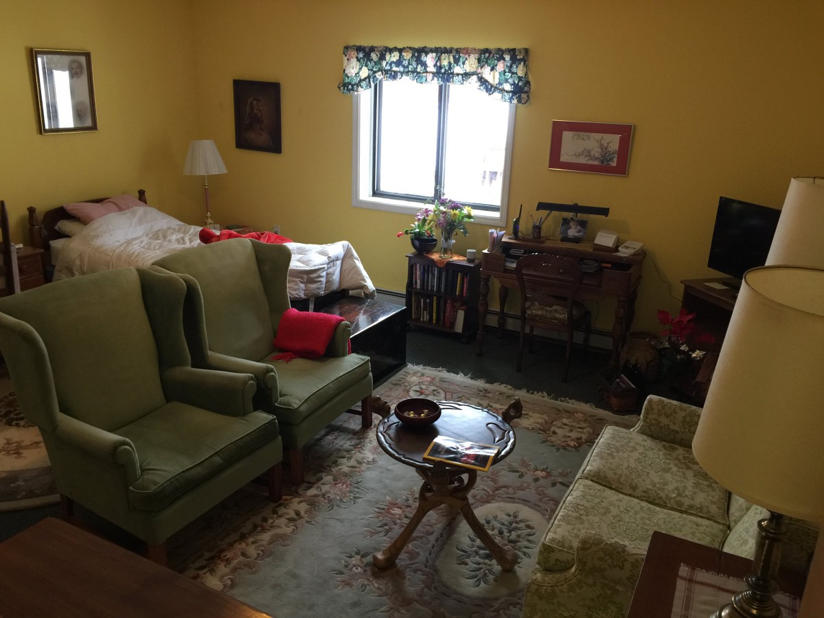 A cozy living room with yellow walls, featuring armchairs, a sofa, a coffee table, and dcor items.