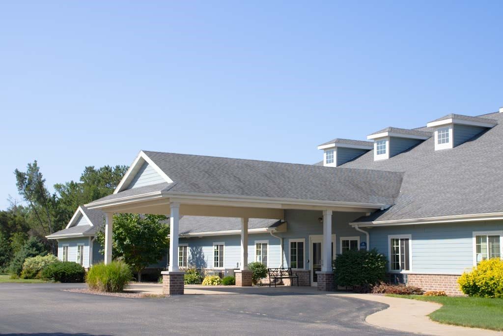A single-story building with a covered entrance and surrounding landscaping.