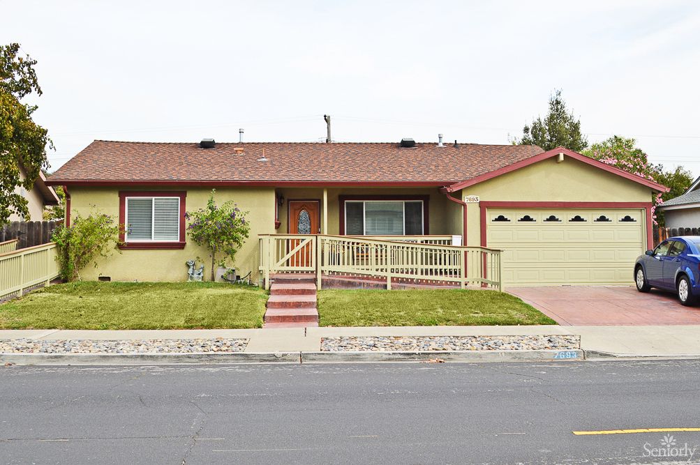 A single-story suburban house with a driveway and front lawn.
