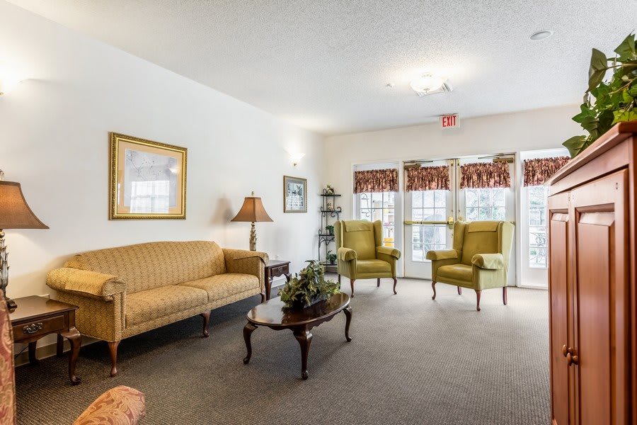 A cozy living room with a sofa, chairs, and a coffee table, featuring classic decor.