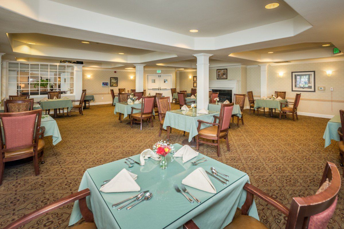 An elegantly set dining room with neatly arranged tables and chairs.