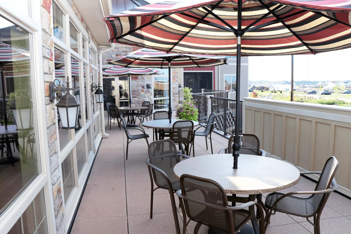 A restaurant patio with tables and umbrellas arranged for outdoor dining.