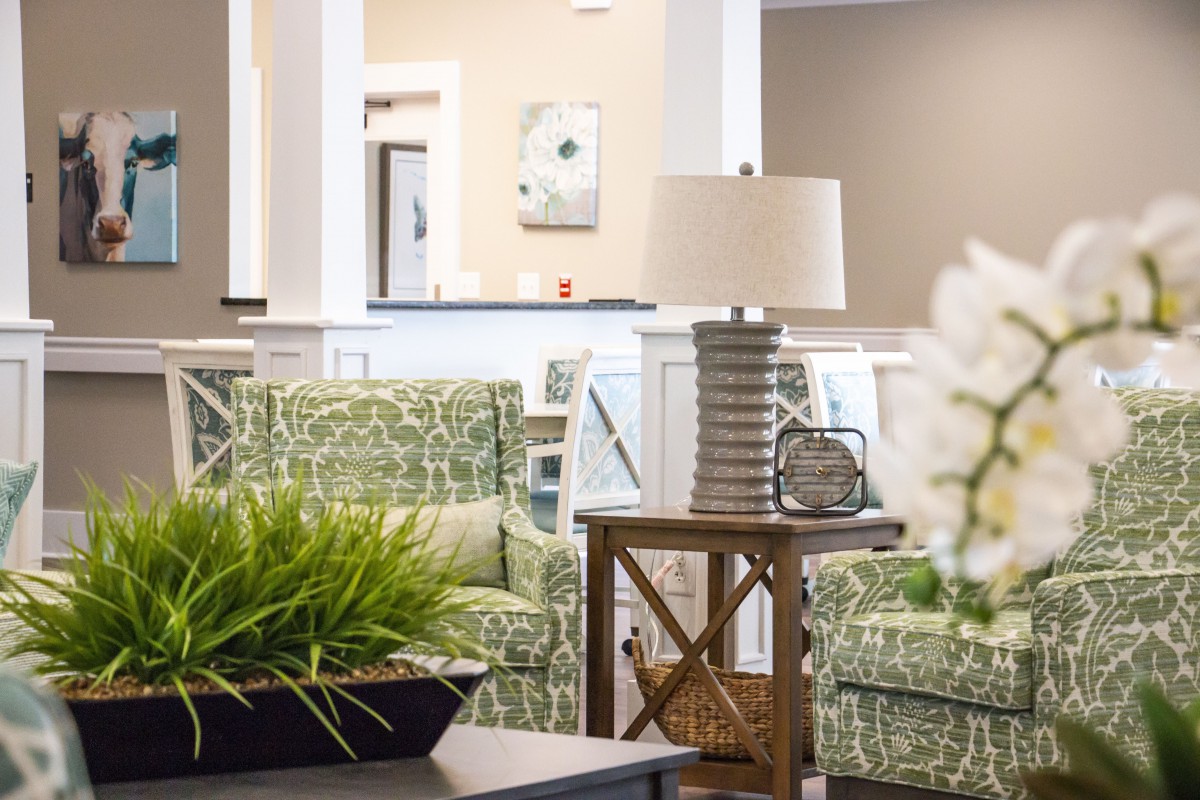 A cozy living room with green patterned furniture and stylish decor.