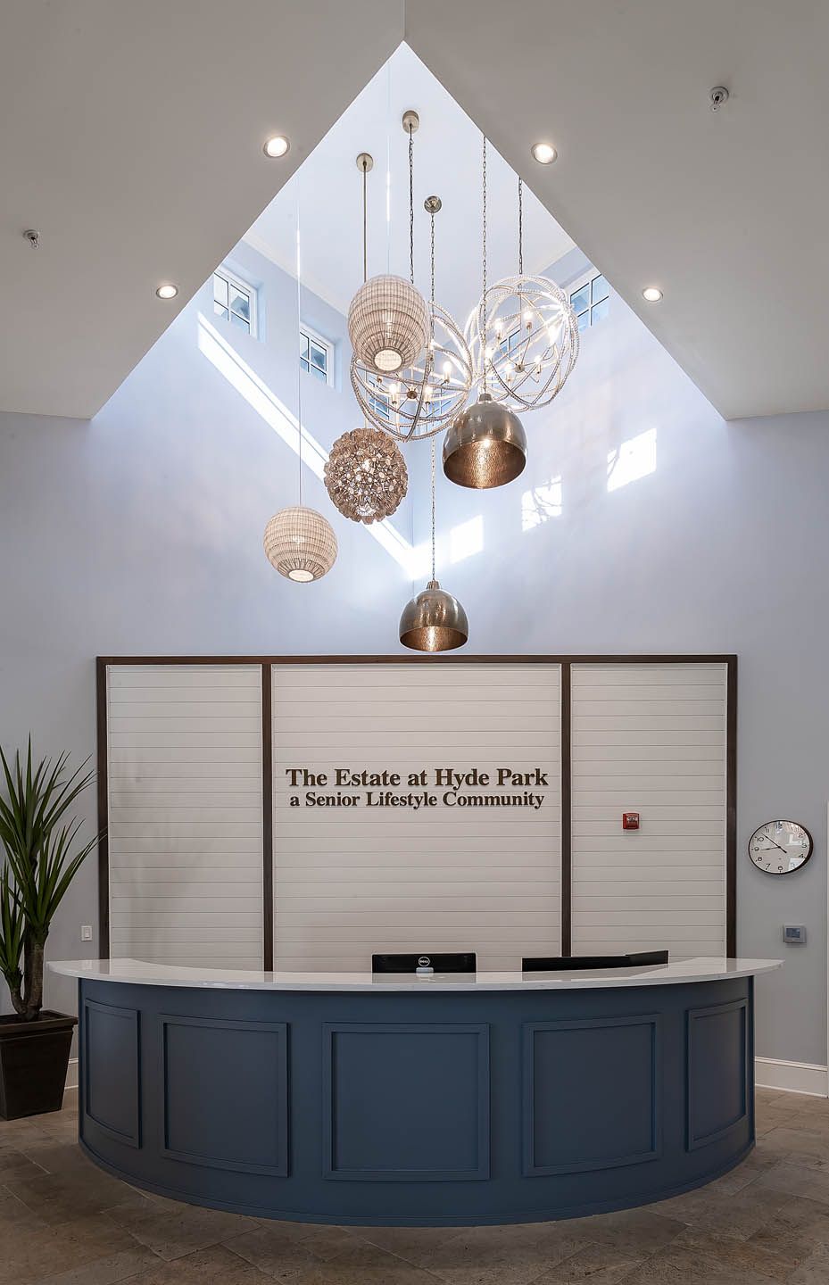 A modern lobby area with a reception desk and stylish chandeliers.
