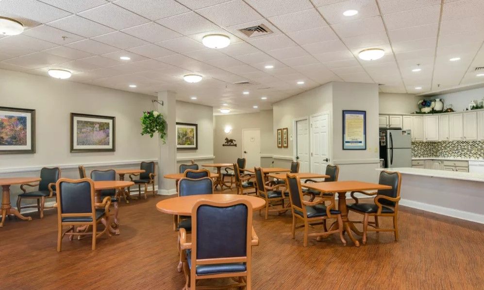 An empty, well-lit dining area with multiple tables and chairs arranged neatly.