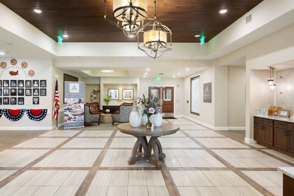 A spacious and elegantly decorated lobby with a central table and chandelier lighting.
