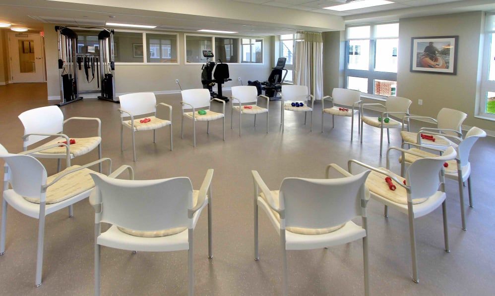 A modern meeting room with chairs arranged in a circle, filled with natural light.