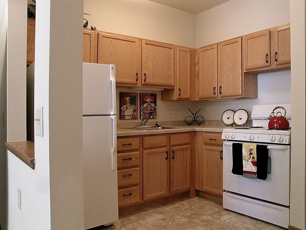 A cozy kitchen with wooden cabinets and standard appliances.