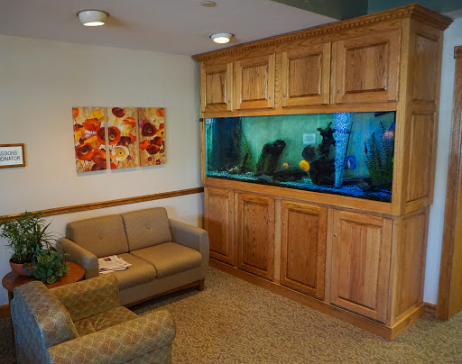 A cozy living room featuring an elegant wooden aquarium and comfortable seating.