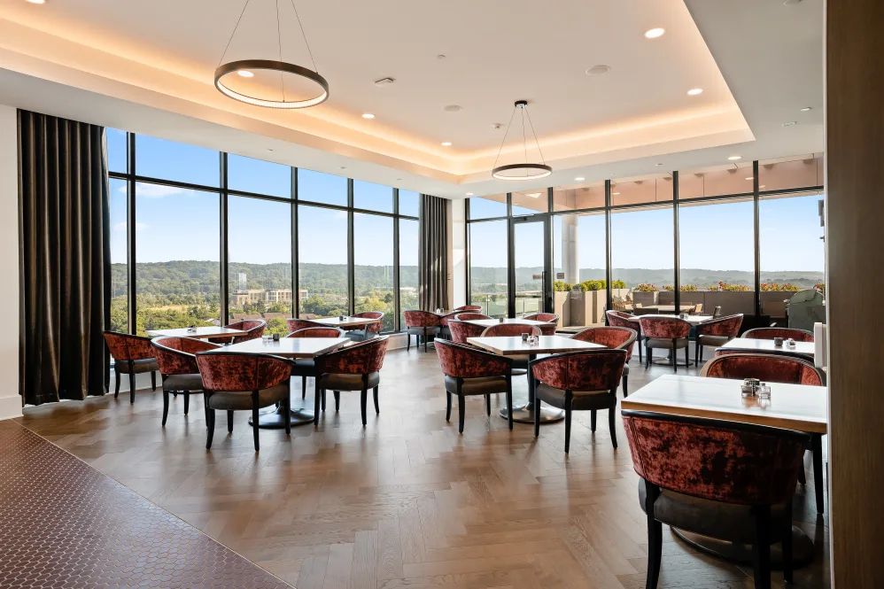 A spacious restaurant dining area with large windows offering a scenic view.