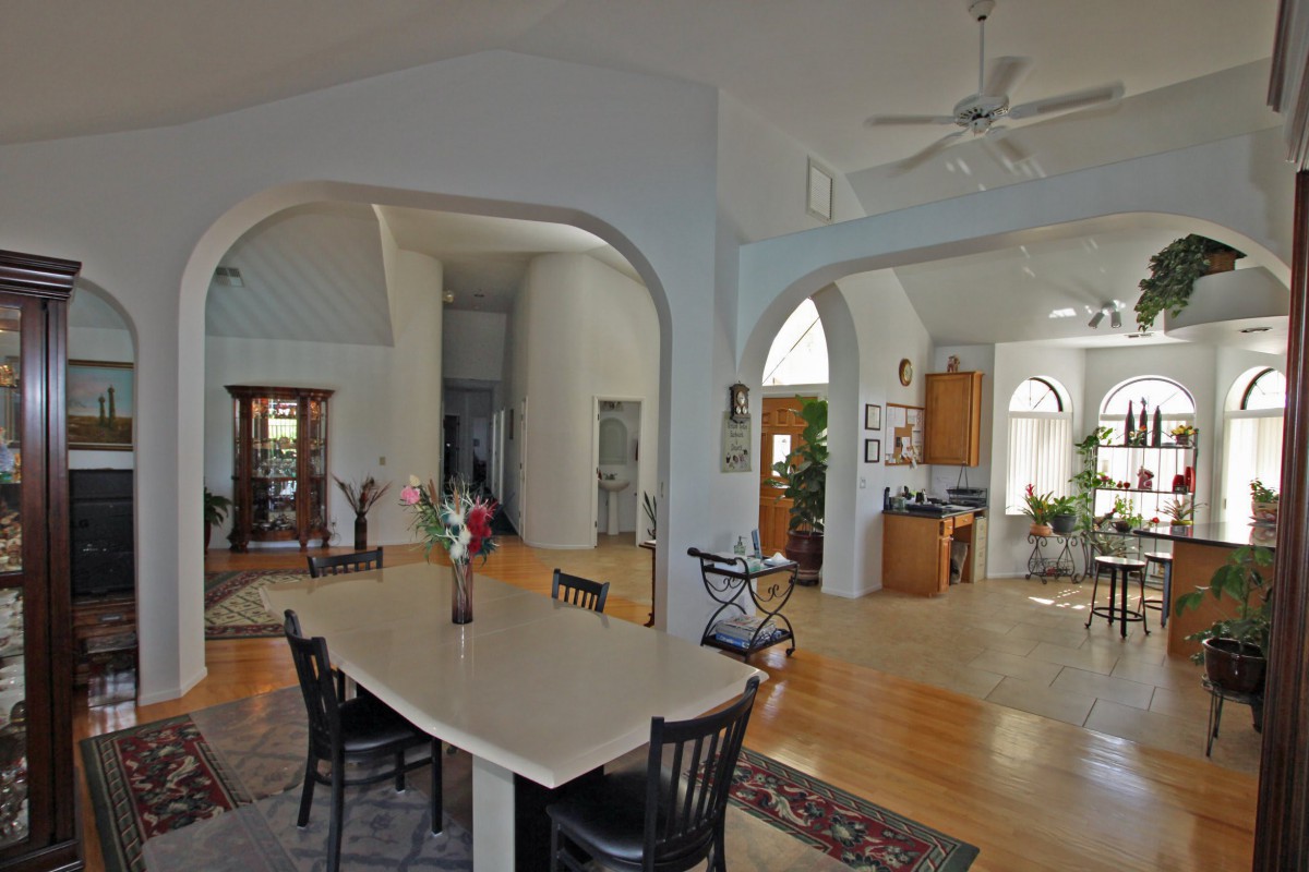 A spacious open-plan interior featuring a kitchen and dining area with high ceilings.