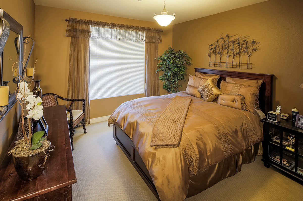 A cozy bedroom with warm beige tones and elegant furnishings.