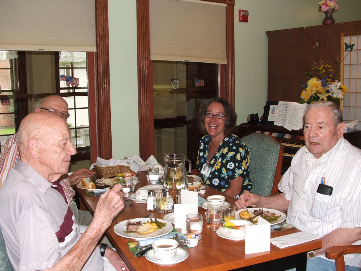 A group of seniors enjoying a meal together at a dining table.