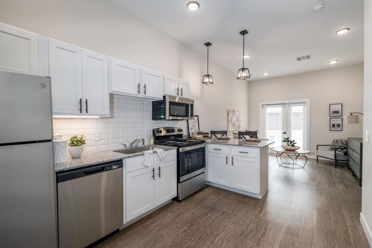 A modern kitchen with white cabinets and stainless steel appliances.