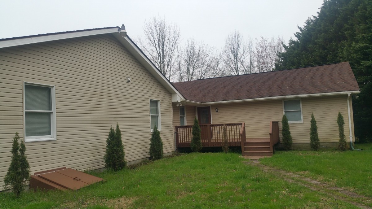 A suburban house with a front porch and green yard.