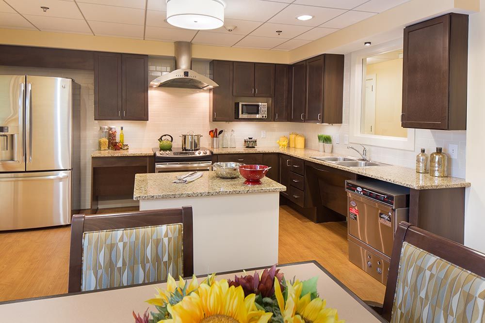 A modern kitchen with dark wood cabinets, stainless steel appliances, and a central island.