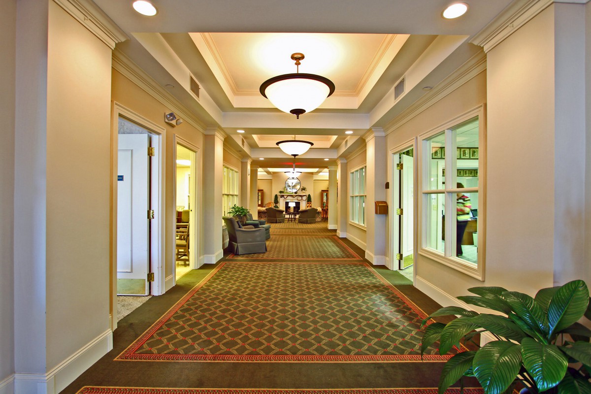 A well-lit hallway with decorative lighting and patterned carpet.
