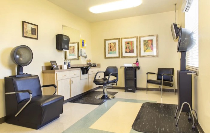 A well-lit hair salon with chairs and artwork on the walls.