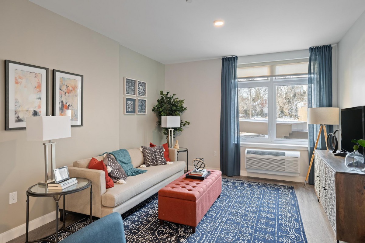A modern living room with a comfortable sofa, decorative pillows, a coffee table, and artwork on the walls.