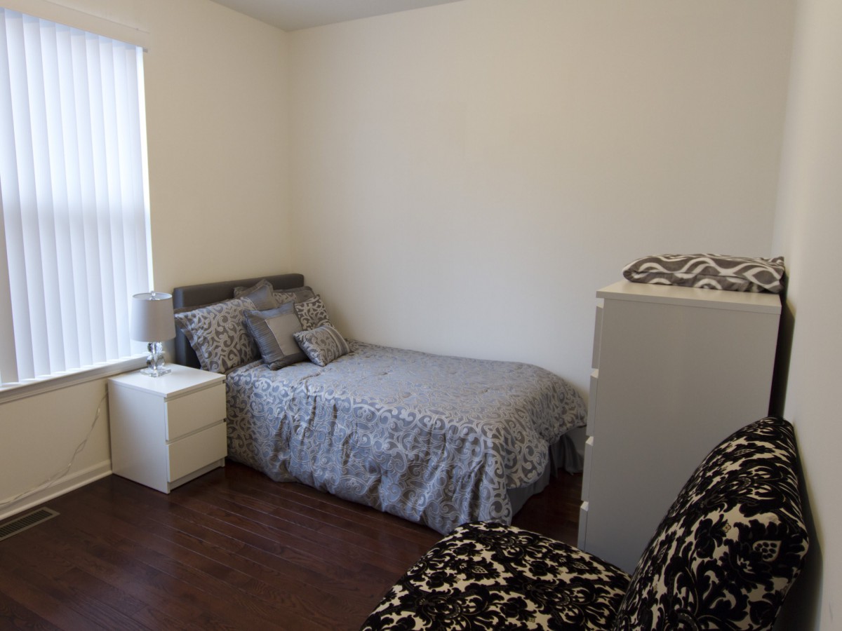 A minimalist bedroom with a bed, nightstand, and simple decor.