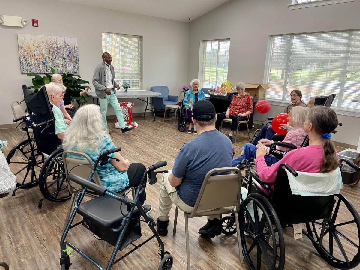 A group of seniors participating in an activity session in a community room.