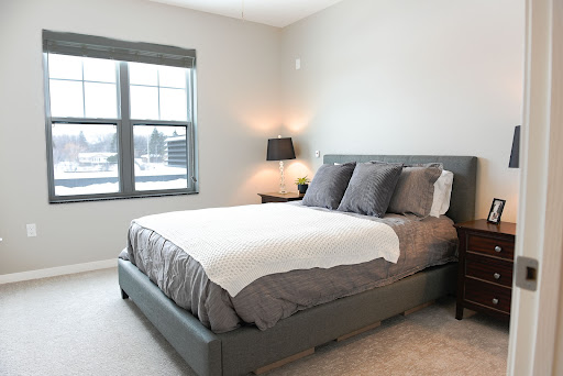 A modern and cozy bedroom featuring a stylish gray bed and soft lighting.