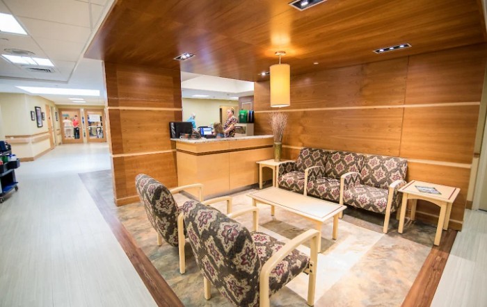 A cozy reception area with patterned seating and wood paneling.