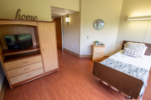 A well-furnished bedroom featuring a comfortable bed, a television unit, and warm wooden accents.