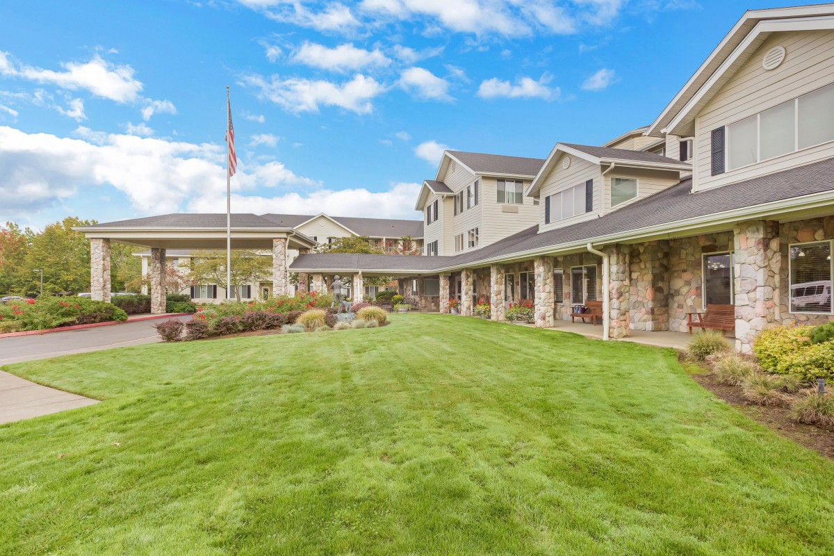 A residential building with a well-manicured lawn under a clear blue sky.