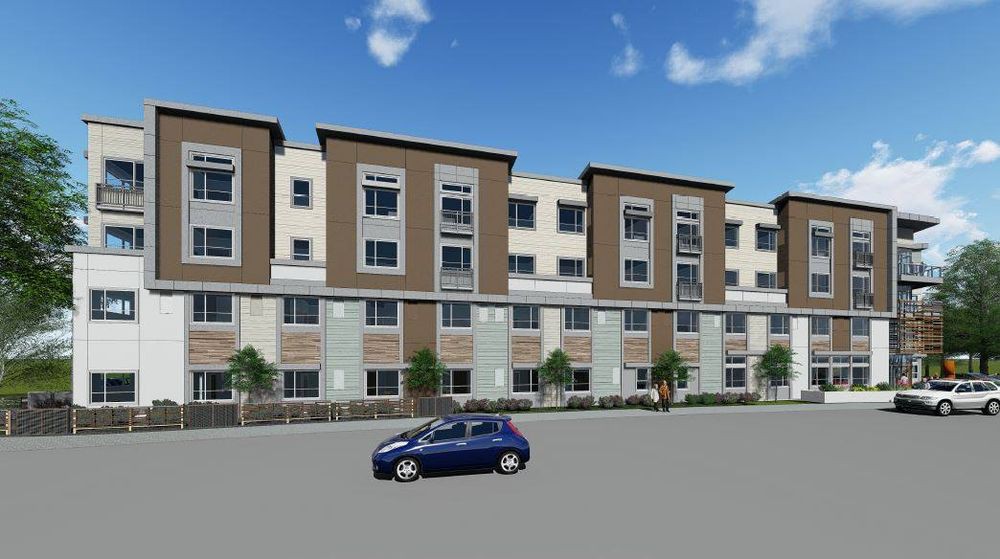 A modern apartment complex with a car parked on the street.
