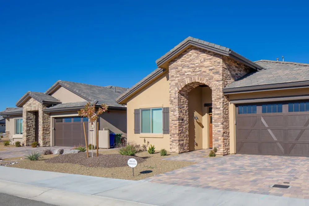 Modern suburban house with a stone facade and two garages.