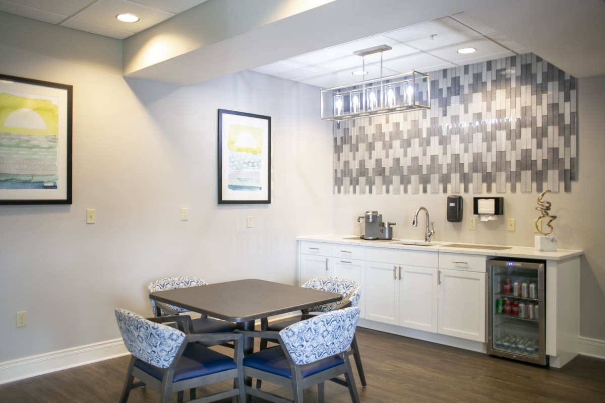 A modern kitchen area with a dining table, chairs, and stylish backsplash.